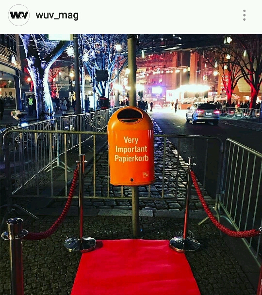 Streetphoto of a bin which has written Very Important Papierkorb written on it with a red carpet in front of it